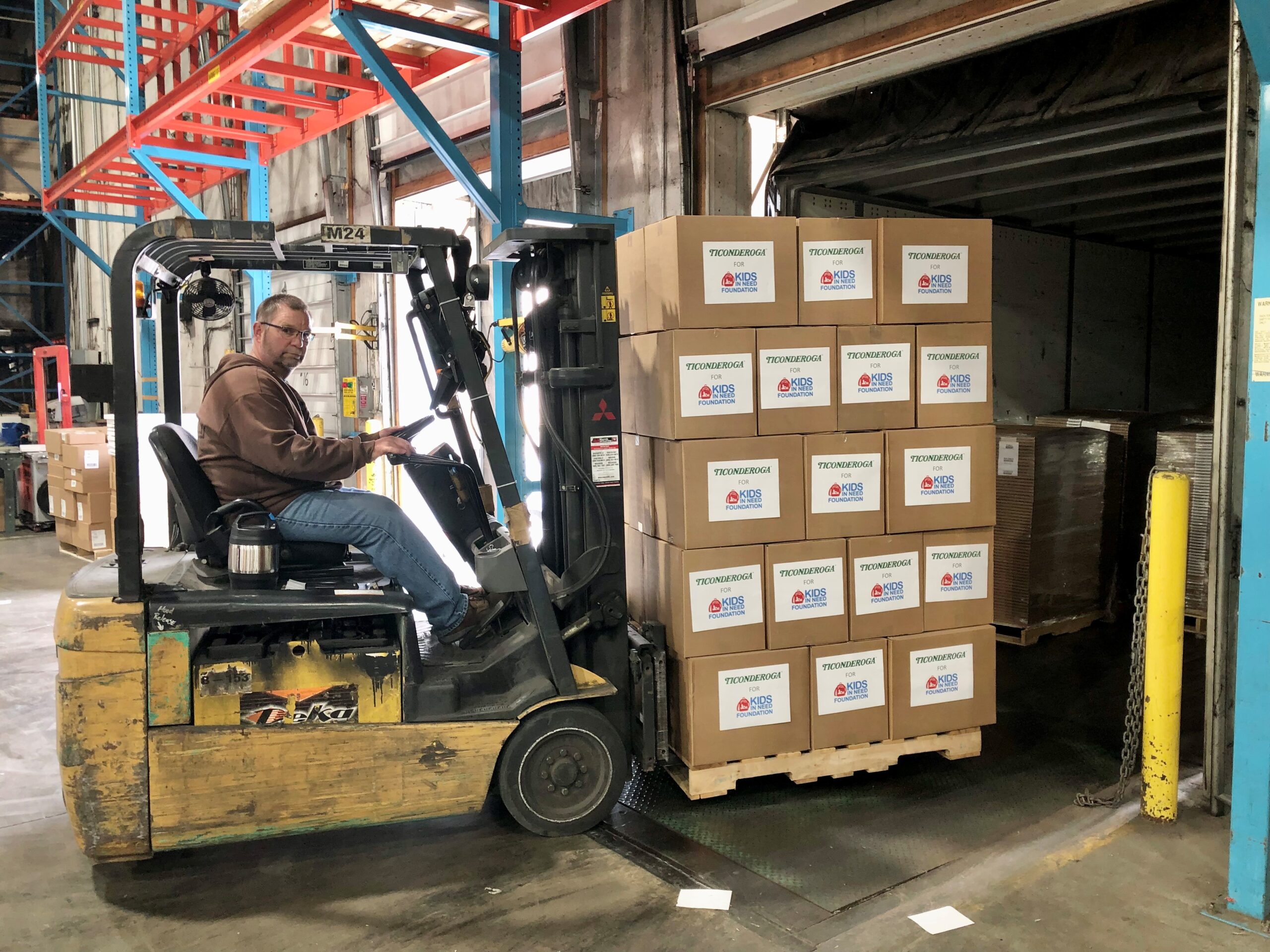 Man loading a donated pallet of Ticonderoga school supplies to ship to Kids In Need Foundation
